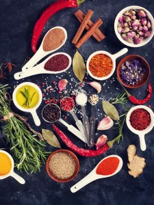 Spoons arranged next to each other with different Indian herbs and spices.